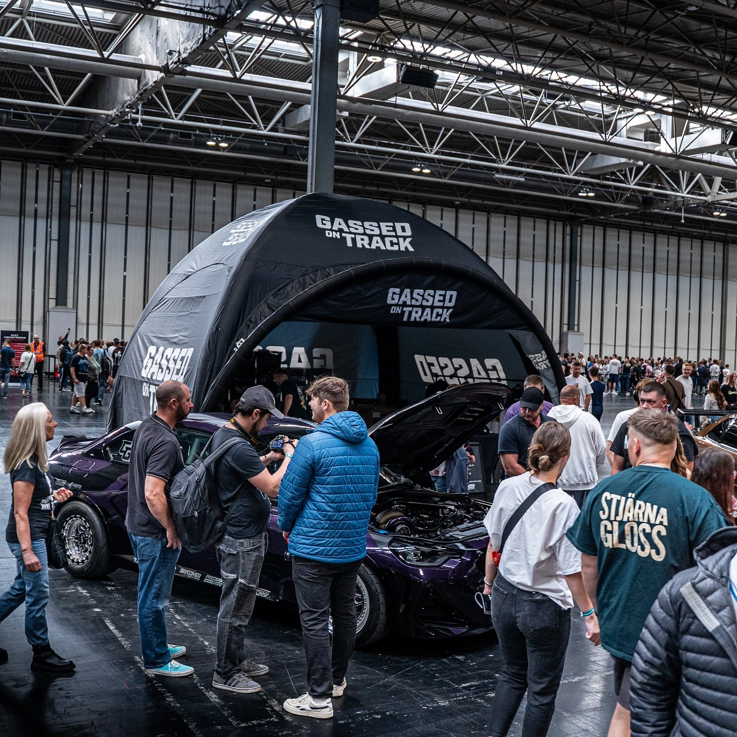 Gassed On Track event booth with crowd and car